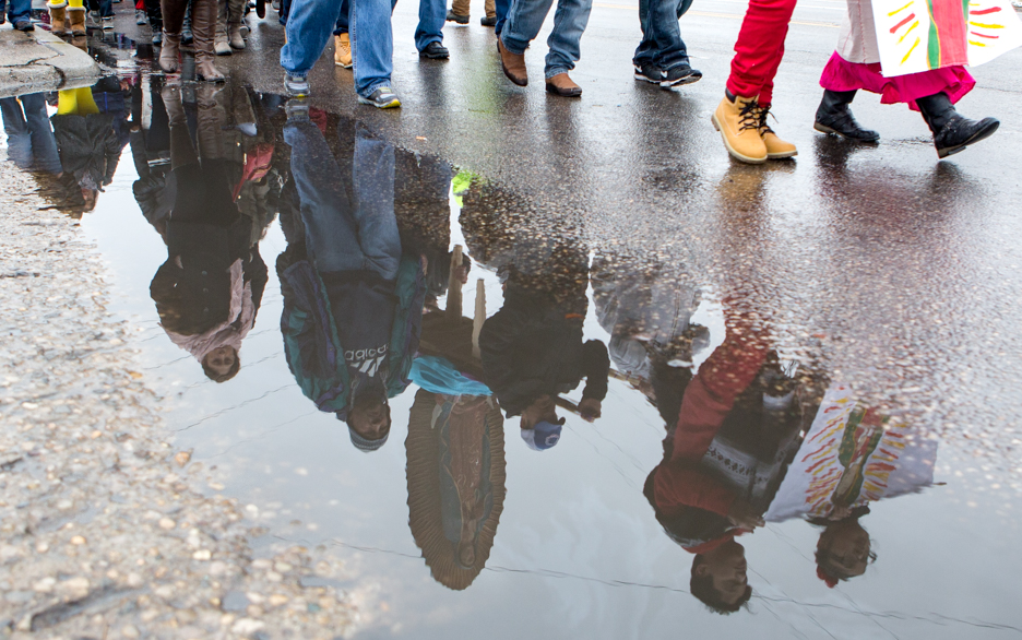 People's faces reflected in a puddle