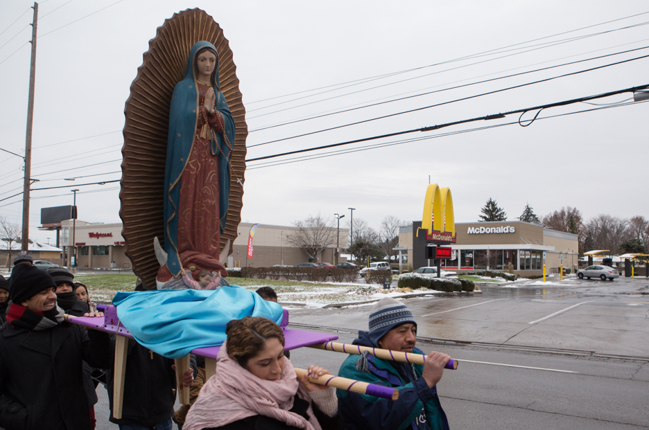 Statue of Mary carried as procession passes McDonalds