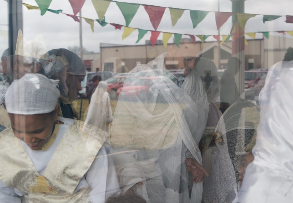 reflection of Ethiopian Orthodox worshippers in window